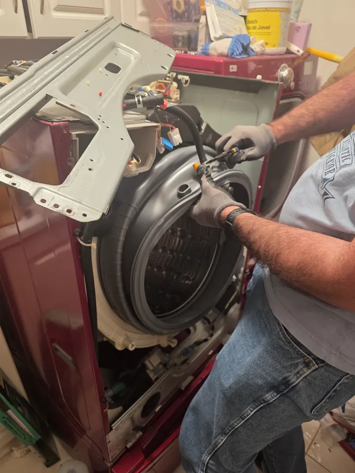 Technician examining an opened laundry appliance
