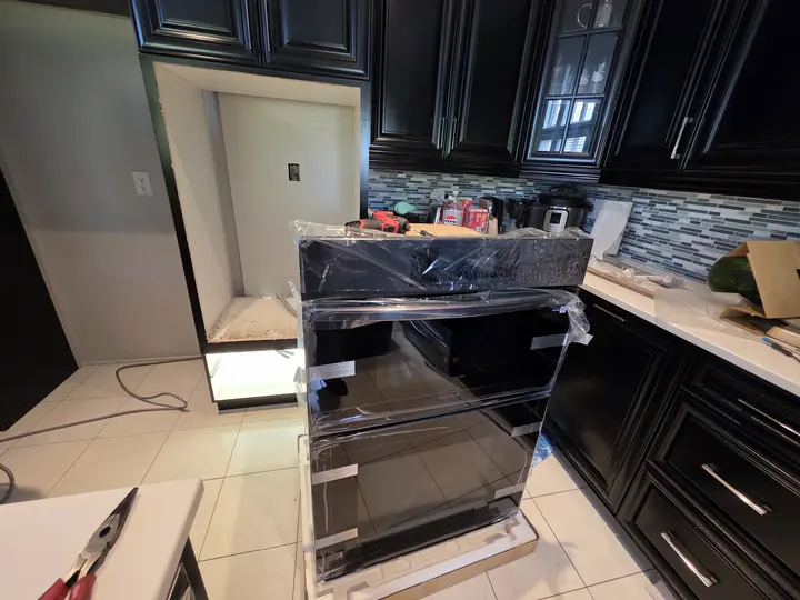 Oven positioned beside its kitchen cabinet during installation